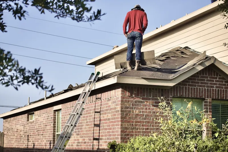 Professional roofer working on a residential roof in Hollins